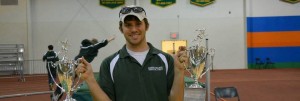 Trach coach holding trophies