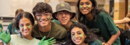 Group of MLWGS students smiling at the camera and wearing green during spirit week